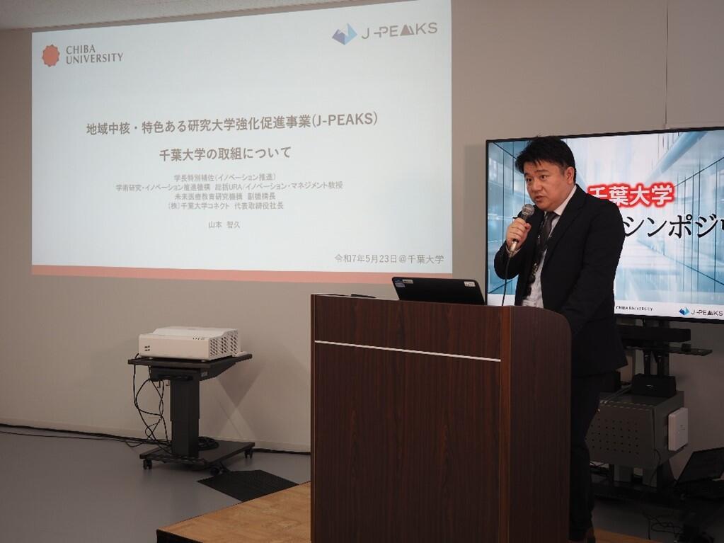 J-PEAKSの概要紹介を行う、山本智久 学長特別補佐