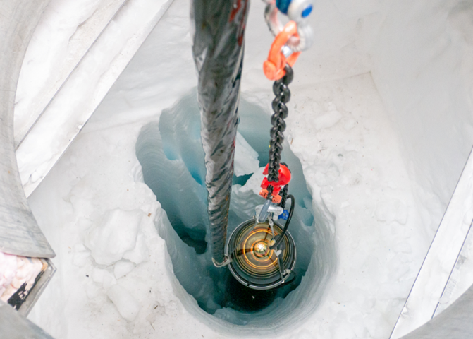 図3 D-Eggがケーブルにつながれ掘削孔に入っていく様子 (photo: Aya Ishihara/IceHap)